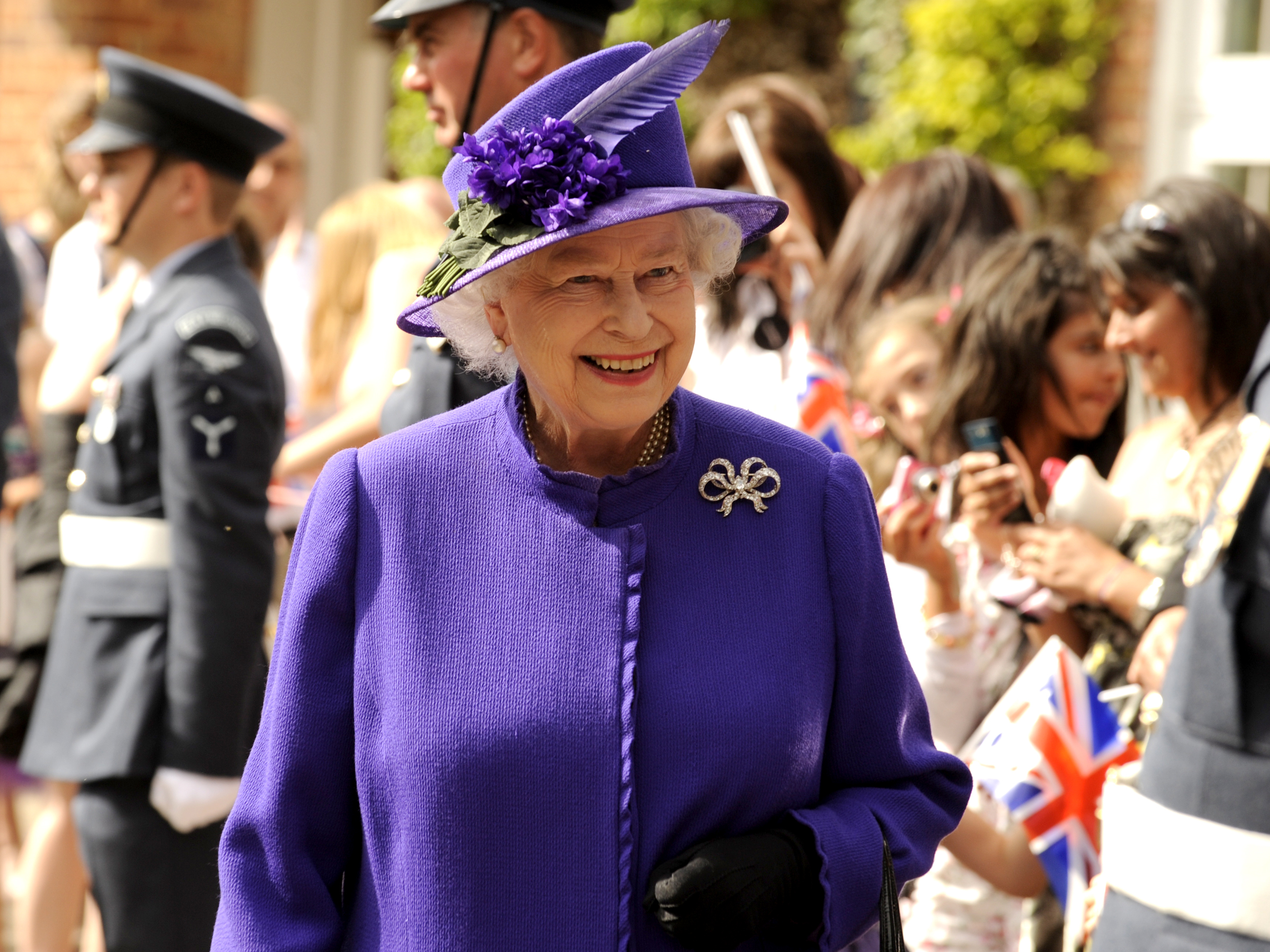 The Queen walks past Aviators and the public.